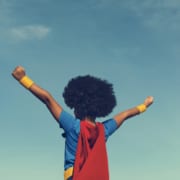 Little boy in a super hero costume arms extended out