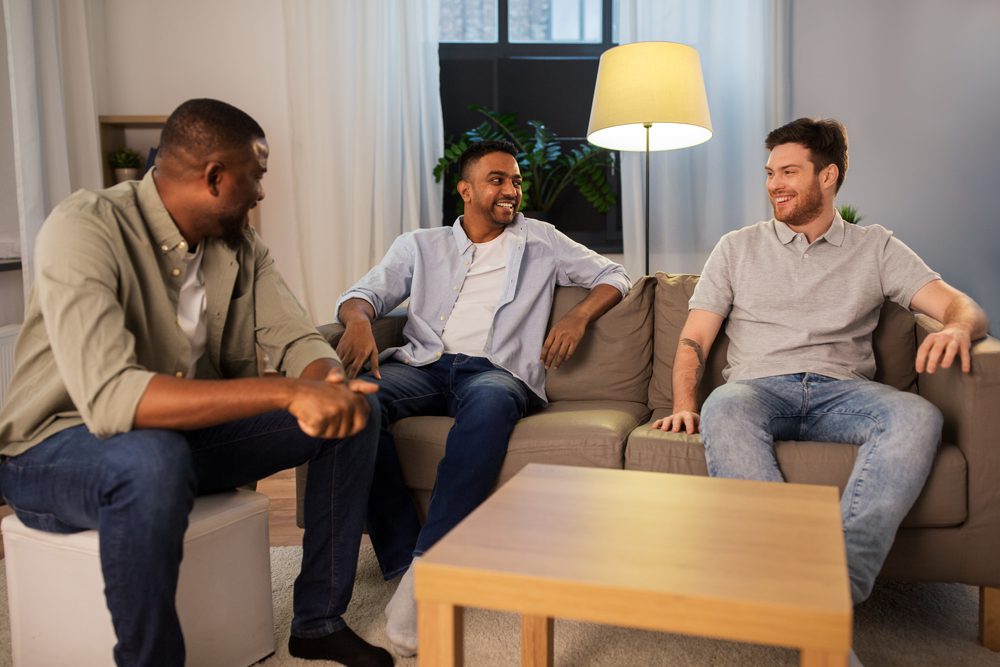 Dads and other male caregivers sitting in a circle sharing stories and supporting each other